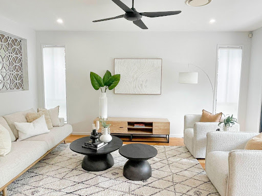 A Stunning, Cosy Living Room with a 5-Seater Sofa and Black Wooden Table, Styled with Vases, Books, and a Touch of Plants Throughout | Property Staging by Sell in Style, Brisbane.